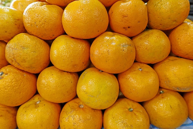 frutas naranjas frescas con hojas en la vista superior como fondo