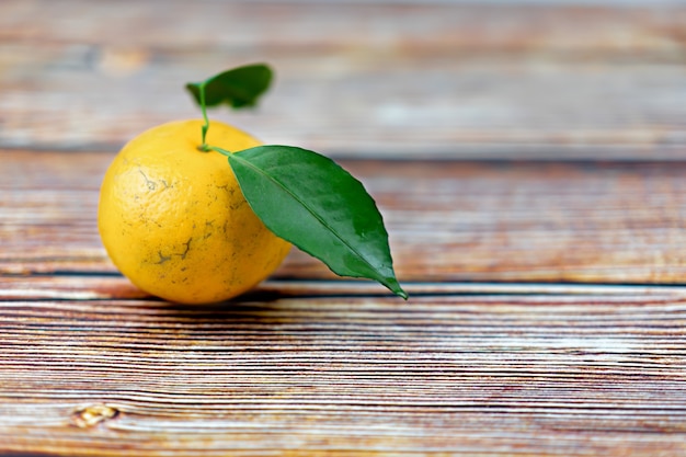 Frutas naranjas con hoja en mesa de madera