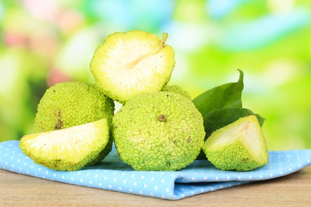 Frutas naranjas Osage Maclura pomifera en cesta sobre mesa de madera sobre fondo de naturaleza