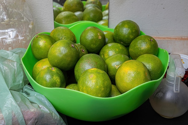 Frutas naranjas en un recipiente verde.