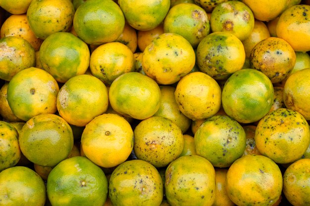 Frutas naranjas sucias orgánicas apiladas en cajas de madera en abarrotes