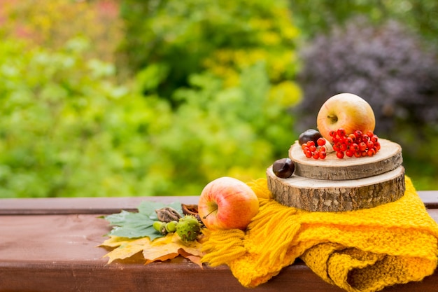 Frutas y nueces, bufanda amarilla sobre la mesa de madera