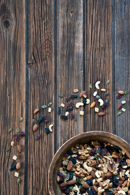 Frutas Nuts y secadas en cuenco de madera en fondo de madera rústico.