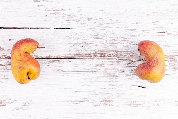 Frutas orgánicas feas peras maduras sobre fondo de mesa de madera blanca con espacio de copia