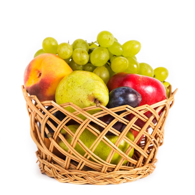 Frutas otoñales en la canasta aislado en blanco