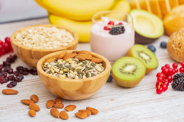 Frutas y pan, cereales integrales y nueces sobre mesa de madera