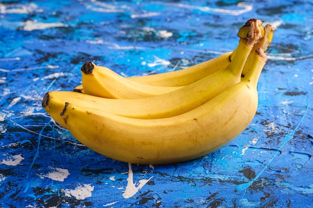 Frutas de plátano en superficie con textura azul, ángulo de visión