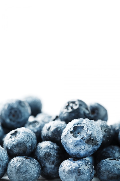 Frutas saborosas de mirtilos estão espalhadas em um branco