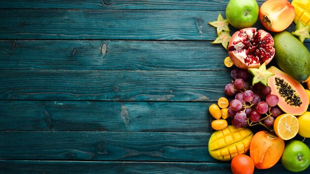 Frutas sazonais e tropicais em um fundo azul de madeira Fundo de comida Vista superior Espaço livre para o seu texto