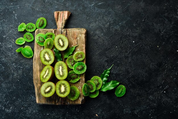 Frutas secas Kiwi confitado y fresco sobre una tabla de madera Sobre un fondo de piedra