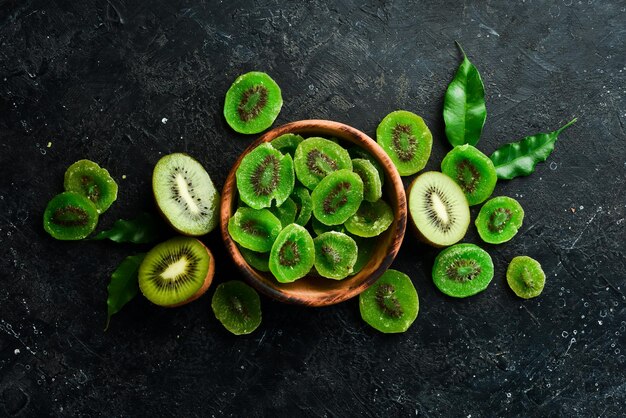 Frutas secas Kiwi cristalizado e fresco em uma placa de madeira Em um fundo de pedra