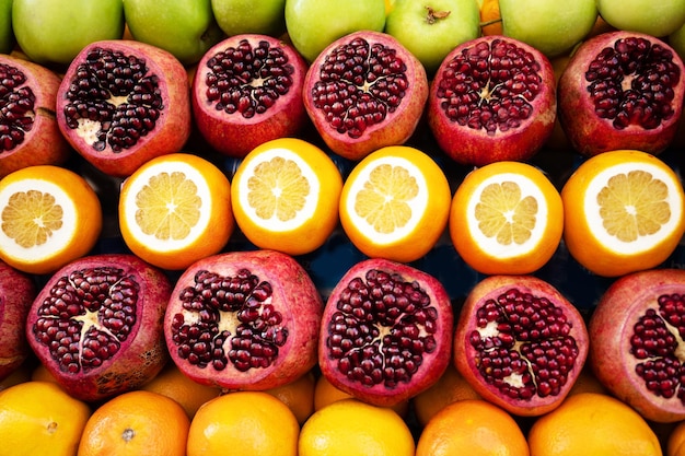 Frutas sortidas com romãs maçãs e laranjas vista superior