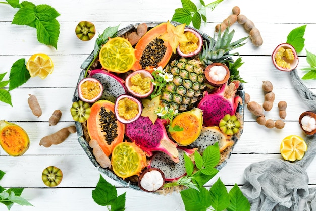 Frutas tropicais em um fundo branco mamão mangostão cacto fruta pytahaya abacaxi Vista superior Espaço livre para texto