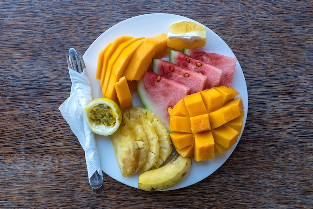 Frutas tropicais em um prato de café da manhã, close-up. melancia fresca, banana, maracujá, abacaxi, jaca, manga, mamão, laranja para comer em restaurante de praia, ilha de zanzibar, tanzânia, áfrica