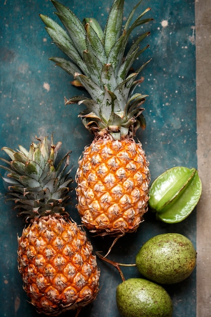 Frutas tropicais maduras em uma mesa de concreto turquesa