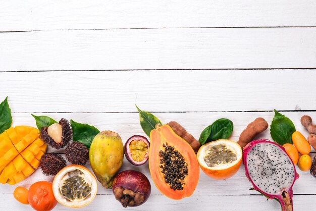 Frutas tropicais mamão Fruta do dragão rambutan tamarindo cacto fruta abacate granadilla carambola kumquat manga mangostão maracujá coco Em um fundo de madeira