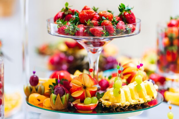 Frutas tropicais repousam em uma travessa servida em uma mesa decorada durante a cerimônia de casamento e banquete