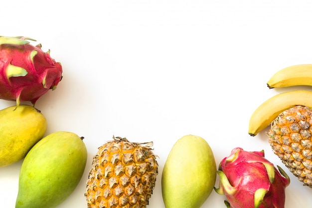 Frutas tropicales aisladas. Piña, plátano, fruta del dragón y mango aislados en blanco. Vista superior.