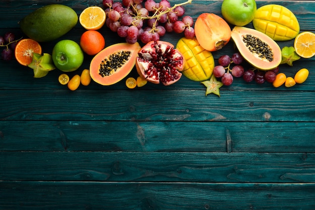 Frutas tropicales y de temporada sobre un fondo de madera azul Fondo de alimentos Vista superior Espacio libre para el texto