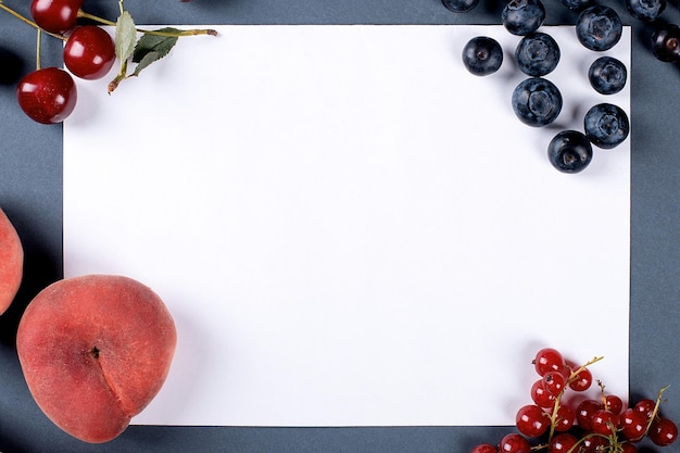 Frutas de verano sobre un fondo gris con un marco para texto melocotón cereza y bayas