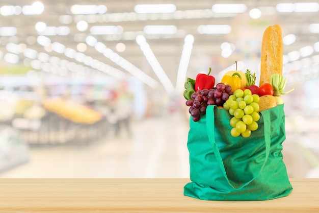 Frutas y verduras en bolsa de compras con fondo de supermercado