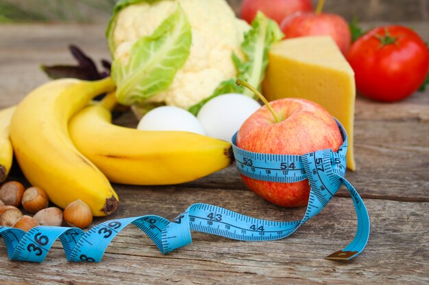 Frutas y verduras, cinta métrica en madera vieja Concepto de nutrición adecuada.