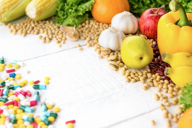 Frutas, verduras, especias y nueces saludables en madera blanca con medicina
