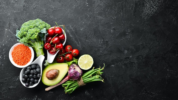 Frutas y verduras frescas sobre fondo negro Vitaminas y minerales Vista superior Espacio libre para el texto