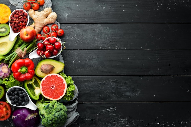 Frutas y verduras frescas sobre fondo negro Vitaminas y minerales Vista superior Espacio libre para el texto