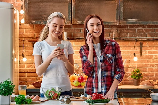 Frutas y verduras los mejores comestibles jóvenes amigas preparando juntos comida vegetariana en