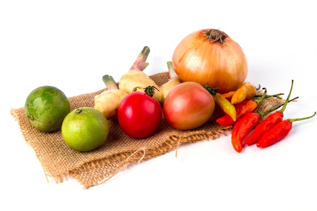 Las frutas y verduras mixtas se colocan en el saco sobre fondo blanco.