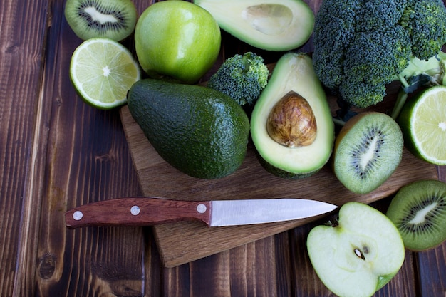 Frutas y verduras verdes en el fondo de madera marrón