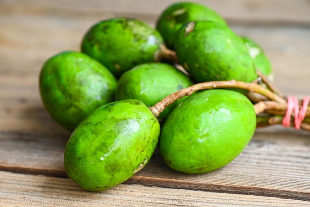 Fruto de Elaeocarpus hygrophilus sobre fondo de madera Spondias mombin