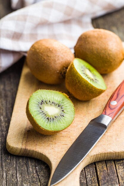 Foto fruto de kiwi cortado a la mitad en la tabla de cortar