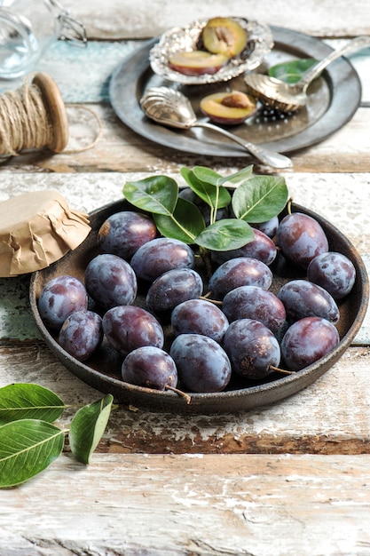 Frutos de ameixa em fundo de madeira rústica. Geléia de compota