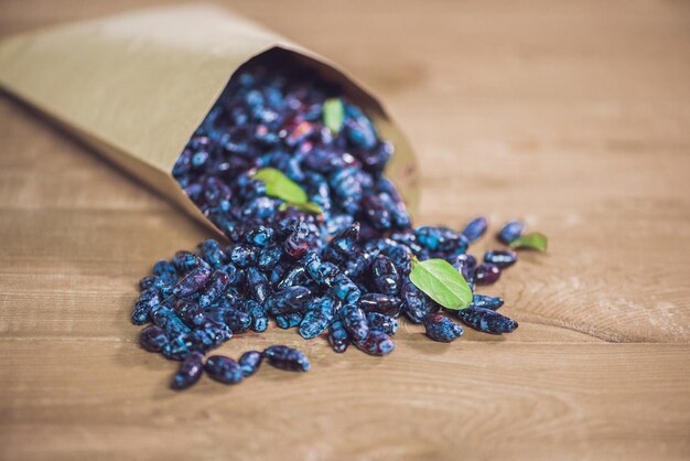 Frutos de baga azul de madressilva fresca com folha em um fundo de madeira.