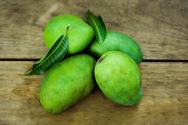 Frutos de manga Harumanis isolados em fundo de madeira