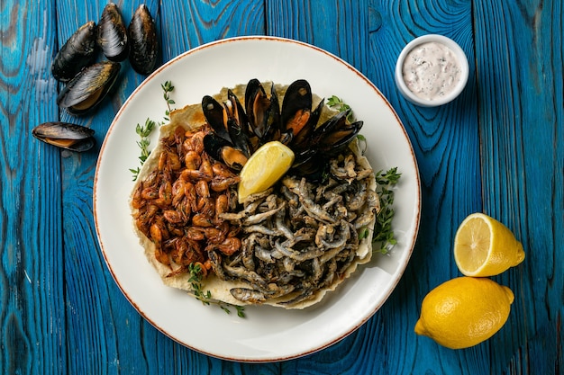 Frutos do mar com limões em uma mesa de madeira