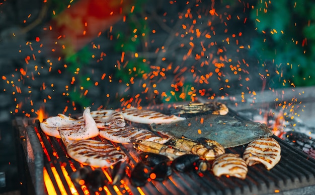 Frutos do mar na grelha, mexilhões, camarão, lula e peixe são cozidos no fogo.