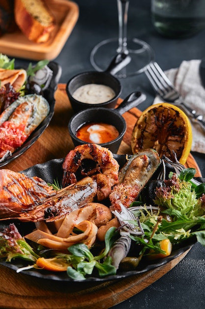 Frutos do mar sortidos em placas bela composição em uma mesa de frutos do mar servida, lulas, camarões, filé de salmão e polvo