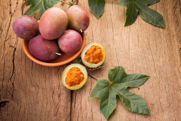 Frutos de gulupa en mesa de madera de vid Passiflora pinnatistipula