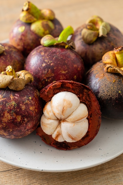 Frutos maduros de mangostão em prato branco