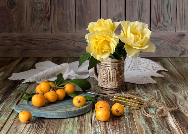 Frutos de níspero y rosas amarillas