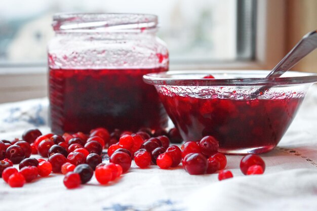 Frutos rojos y mermelada en la ventana.