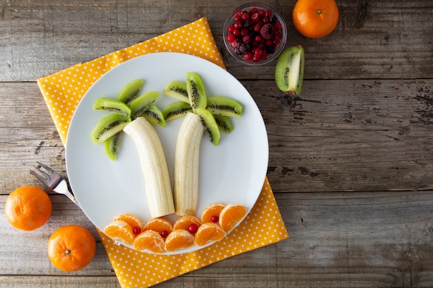 Frutos saudáveis para crianças, banana do quivi e palmeira da tangerina.