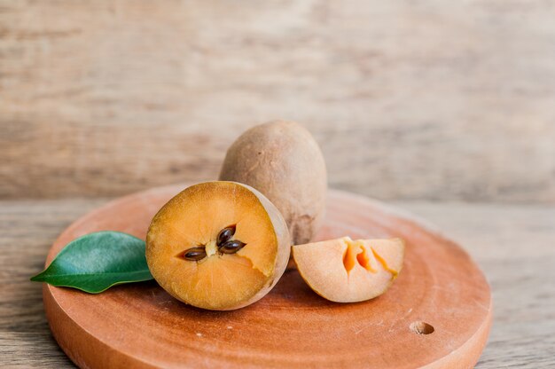 Frutos de zapote fresco sobre fondo de madera vieja