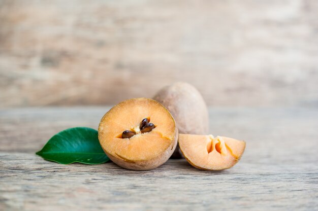 Frutos de zapote fresco sobre fondo de madera vieja