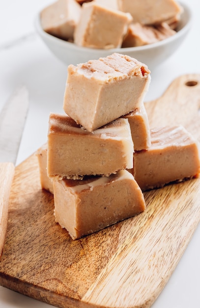 Fudge de mantequilla de maní cruda vegana sobre una tabla de madera