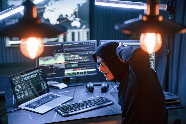 Fue atrapado con las manos en alto hacker profesional masculino está sentado por la concepción de la computadora del virus