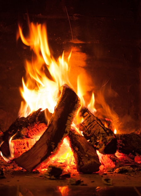 Fuego ardiente en la chimenea de ladrillo, cerrar